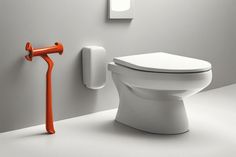 a white toilet with an orange handle next to it and a mirror on the wall