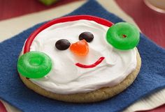 a frosted snowman cookie sitting on top of a blue napkin