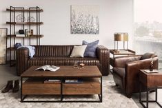 a living room with leather couches and coffee table in front of a large window