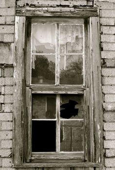 an old window with broken glass on the outside