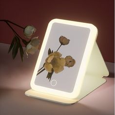 a white light up mirror with flowers on it