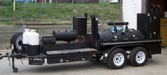 a black truck parked in front of a building with a gas tank attached to the back