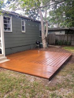 a wooden deck in front of a gray house