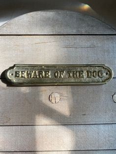 a metal sign that says beware of the dog on it's back side