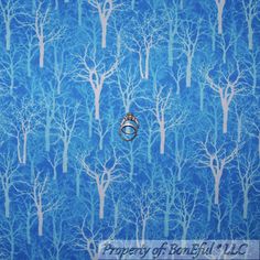 a ring is sitting in the middle of a blue forest wallpapered with trees