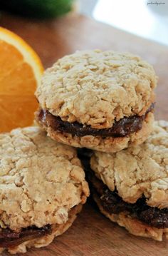 three cookies are stacked on top of each other with an orange in the back ground