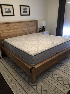 a bed with a wooden headboard and foot board on top of it in a bedroom