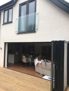 an open garage door with furniture in the middle and windows on each side, outside