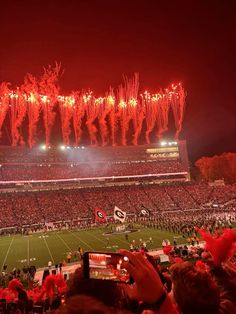 a stadium filled with lots of people watching fireworks