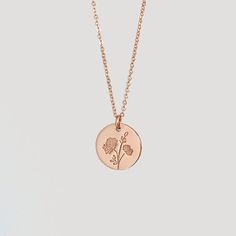 a gold necklace with a flower on it