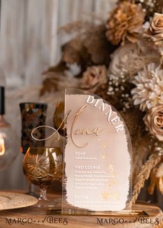 a table with some wine glasses on top of it and flowers in the back ground