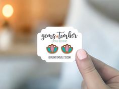 a person holding up a sticker with the words gems and tinder on it