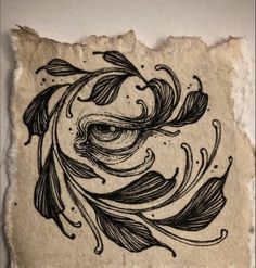 a piece of paper with an ink drawing on it that has leaves and swirls