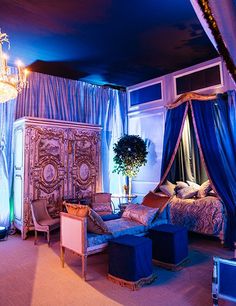 a fancy bedroom with blue curtains and furniture