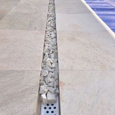 a row of rocks sitting on top of a tiled floor next to a swimming pool