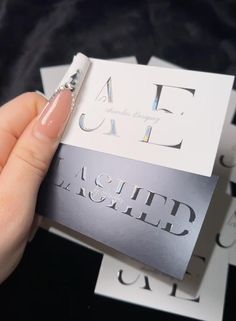 a hand holding a business card with the letter e on it