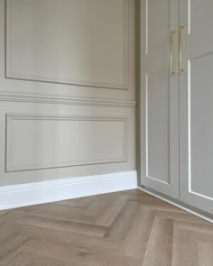 an empty room with white walls and wood flooring is pictured in this image, there are two doors on either side of the wall