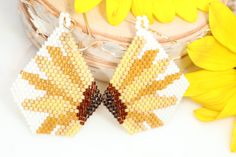 Add a little flower power to your life with our boho seed bead sunflower earrings. These beauties make the perfect statement pieces! Hand beaded dangles shades of sunshine yellow, gold, and mustard that make the perfect gift for a gardener or flower lover. 2.25 inches long 1.25 inches wide They shipped wrapped in tissue & boxed ready to gift or to treat yourself! Each pair is made to order. Shipped in 3-5 business days Yellow Beaded Earrings With Ear Wire For Summer, Summer Yellow Beaded Earrings With Ear Wire, Handmade Brown Beaded Summer Earrings, Handmade Brown Beaded Earrings For Summer, Bohemian Yellow Sunflower Earrings, Yellow Tiny Beaded Earrings For Festival, Yellow Beaded Earrings With Ear Wire For Festivals, Yellow Tiny Beads Earrings For Festival, Handmade Yellow Beaded Earrings For Festival