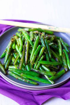 asparagus on a plate with chopsticks next to it