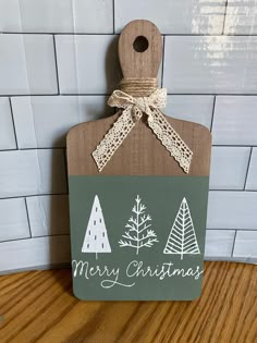 a wooden sign that says merry christmas with trees and snowflakes on the front