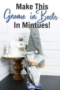 a gnome statue sitting on top of a table next to a small white birdhouse