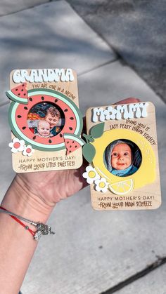 someone holding up two magnets that have pictures on them and the words grandma written on them