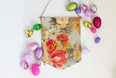 an easter banner hanging on a wall with colorful eggs around it