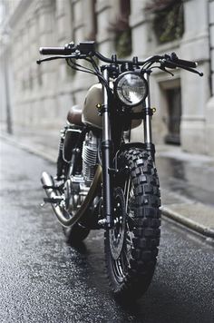 the motorcycle is parked on the side of the street in front of an old building