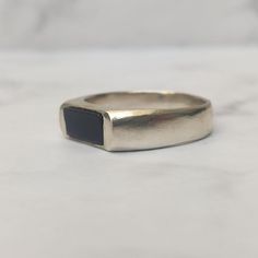 This black onyx signet ring is the perfect addition to any man's jewelry collection. The ring is made of solid 925 sterling silver and features, black onyx stone set in a simple yet elegant design. The black onyx stone is said to be a stone of protection and strength. It is also a popular choice for signet rings because of its durability and timeless appeal. This ring is perfect for everyday wear or for special occasions. It is also a great gift for any man who appreciates stylish jewelry. Gemstone: Black Onyx Material: 925 Sterling Silver Great gift for the one you love or yourself! All products come with a gift box. For more sterling silver rings: https://www.etsy.com/il-en/shop/GalitFCherakov?ref=condensed_trust_header_title_sold&section_id=12036671 Back to my shop: https://www.etsy.com Men Signet Ring, Onyx Ring Men, Mens Ring Designs, Pinky Signet Ring, Onyx Signet Ring, Wide Silver Ring, Blue Opal Ring, Signet Ring Men, Signet Rings