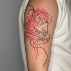 a woman's arm with a tattoo on it that has red flowers in the center