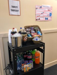 a shelf with drinks and snacks on it next to a sign that says thirsty tuesday