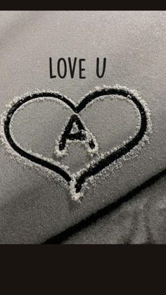 a heart drawn in the snow on top of a blanket with an i love u written on it