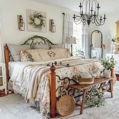 a bed room with a neatly made bed and a chandelier hanging from the ceiling