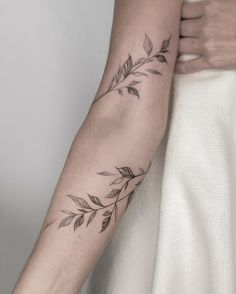 a woman's arm with leaves on it