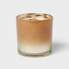 an image of a candle that is in the middle of a white and gold color