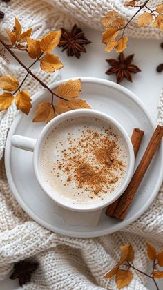 an overhead view of a cup of coffee and cinnamon sticks