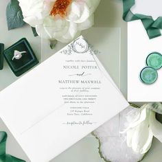 wedding stationery with rings and flowers on the table