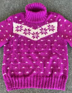 a purple sweater with white stars on it and a pink turtle neck top that is knitted