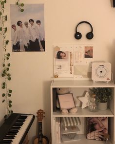 a room with a piano, headphones and pictures on the wall next to it