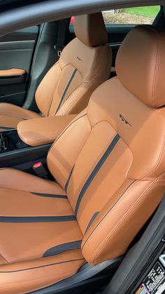 the interior of a car with tan leather and black stitching on the front seats