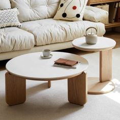 a white coffee table sitting in front of a couch next to a wooden end table