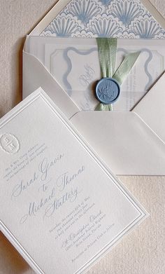 the wedding stationery is set on top of an envelope