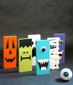 several different colored boxes with faces on them and one has a ball in front of it