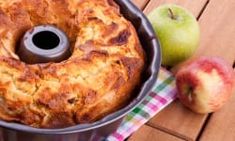 an apple and cinnamon bundt cake in a pan with two apples on the side