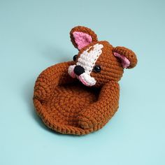 a crocheted teddy bear sitting on top of a blue surface