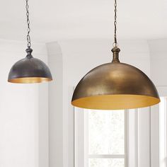 two pendant lights hanging from a ceiling in a room with white walls and flooring