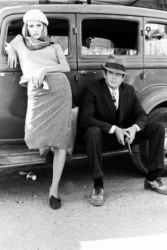 a man and woman sitting on the back of an old car