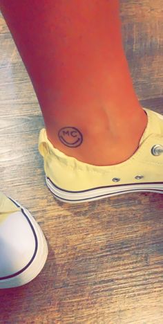 a person with a smiley face tattoo on their foot