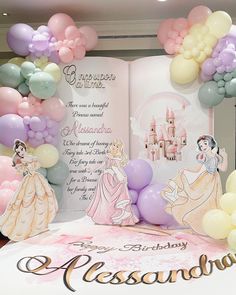 an open book with princesses and balloons on the cover in front of a backdrop