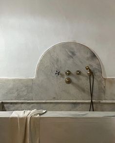 a white bath tub sitting in a bathroom next to a wall mounted faucet